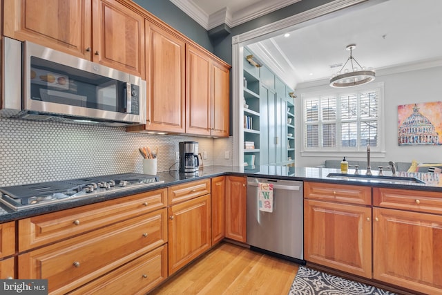 kitchen featuring sink, ornamental molding, hanging light fixtures, and appliances with stainless steel finishes