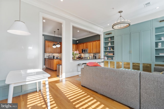 living room featuring crown molding, light hardwood / wood-style flooring, and a notable chandelier