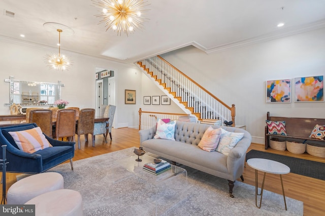 living room featuring a notable chandelier, crown molding, and light hardwood / wood-style floors