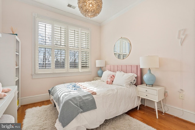 bedroom featuring crown molding and light hardwood / wood-style flooring