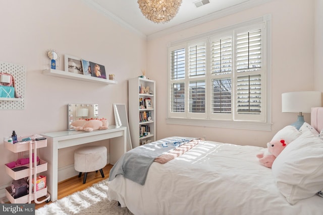 bedroom featuring ornamental molding and light hardwood / wood-style floors