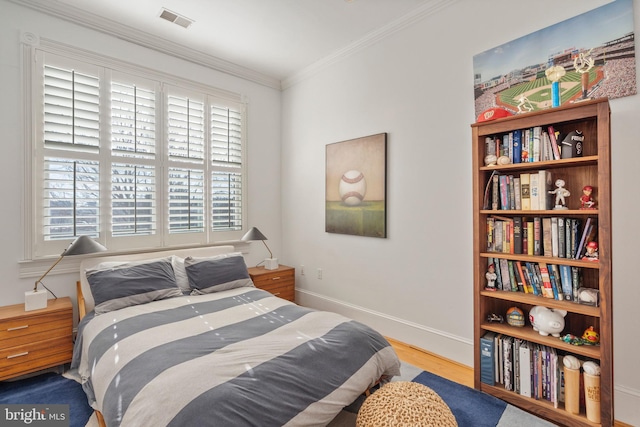 bedroom with ornamental molding and hardwood / wood-style floors