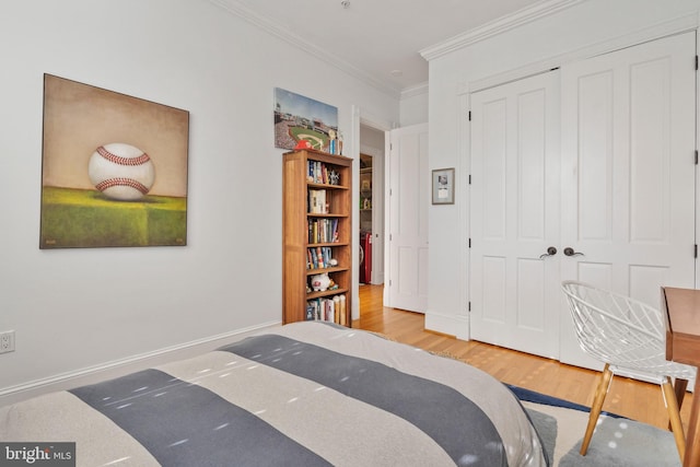 bedroom featuring ornamental molding, light hardwood / wood-style floors, and a closet