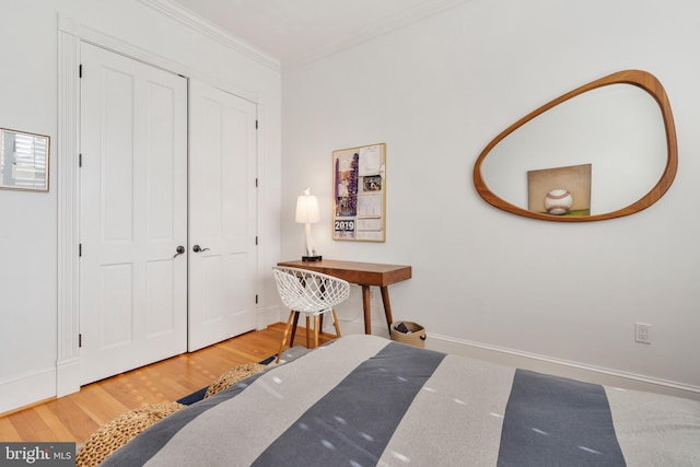 bedroom featuring crown molding, wood-type flooring, and a closet