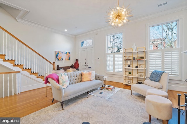 living room with crown molding, wood-type flooring, and a chandelier