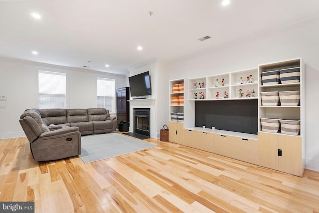 living room with light hardwood / wood-style flooring and ornamental molding