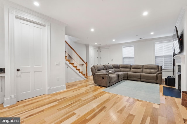 living room featuring crown molding and light hardwood / wood-style flooring