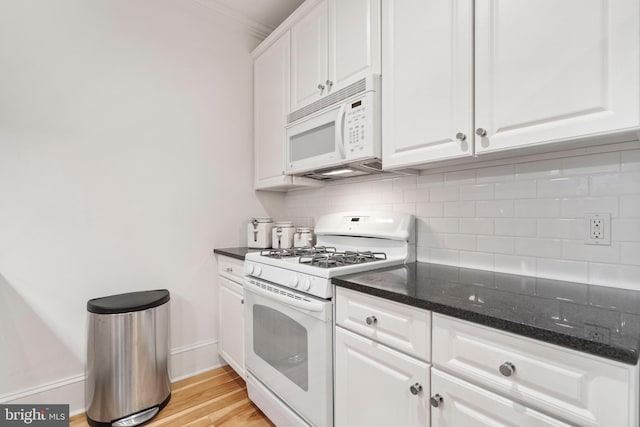 kitchen featuring backsplash, white cabinets, white appliances, and dark stone counters