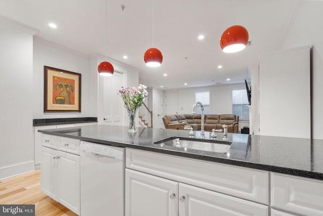 kitchen featuring hanging light fixtures, sink, white cabinets, and dishwasher