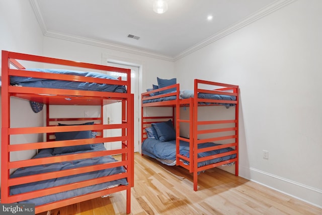 bedroom with crown molding and hardwood / wood-style flooring