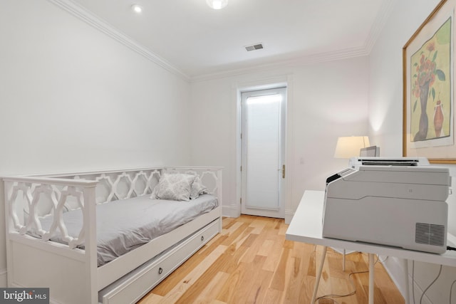 bedroom with crown molding and light hardwood / wood-style flooring