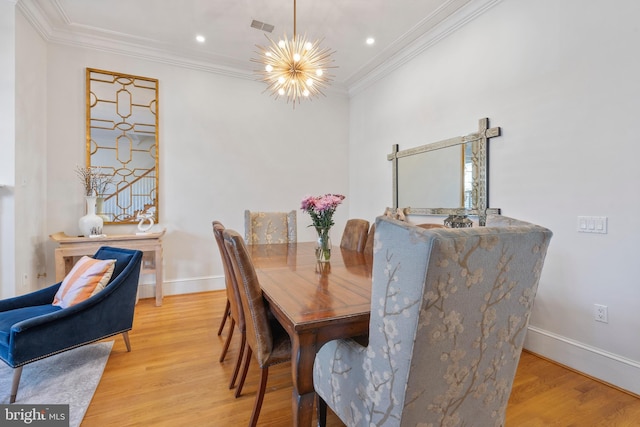 dining area featuring ornamental molding, light hardwood / wood-style floors, and a chandelier