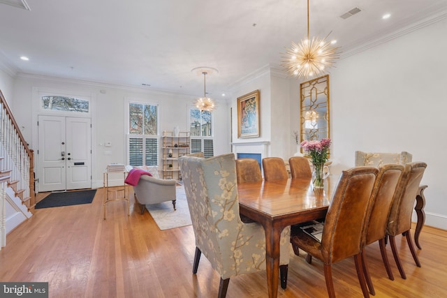 dining area featuring ornamental molding, a chandelier, and light wood-type flooring