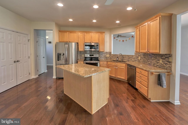 kitchen featuring light brown cabinetry, sink, light stone counters, appliances with stainless steel finishes, and ceiling fan