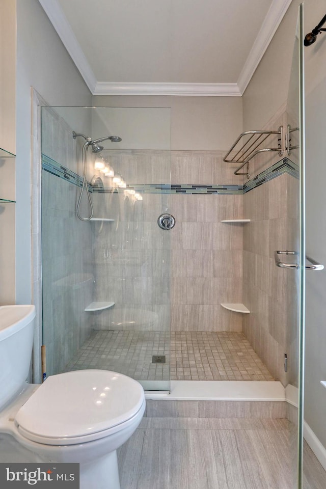 bathroom with walk in shower, ornamental molding, and toilet