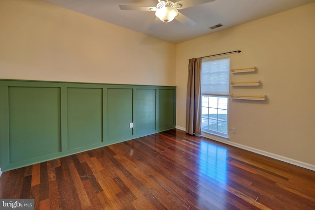 spare room featuring dark wood-type flooring and ceiling fan