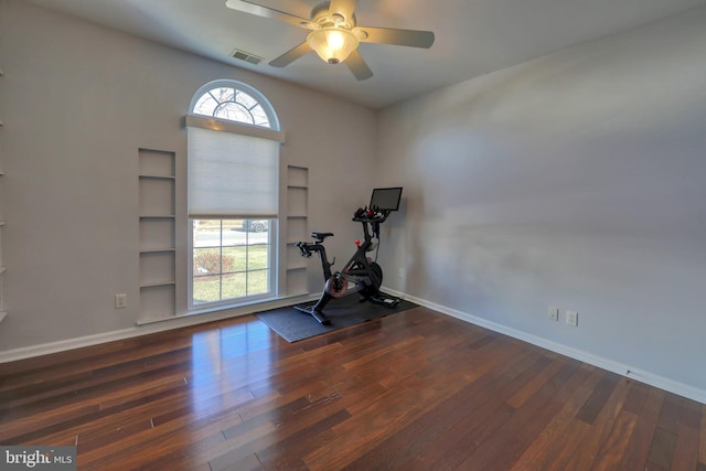 workout room featuring dark hardwood / wood-style floors, ceiling fan, and built in shelves