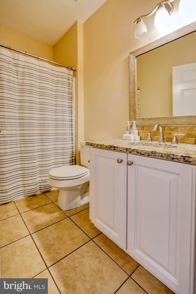 bathroom with tasteful backsplash, tile patterned floors, toilet, and vanity