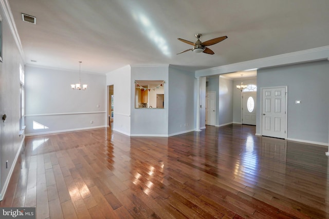 unfurnished living room featuring dark wood-type flooring, ornamental molding, and ceiling fan with notable chandelier