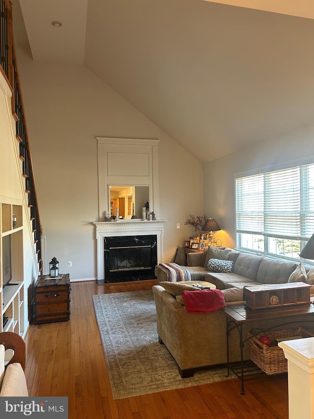 living room with hardwood / wood-style flooring and high vaulted ceiling