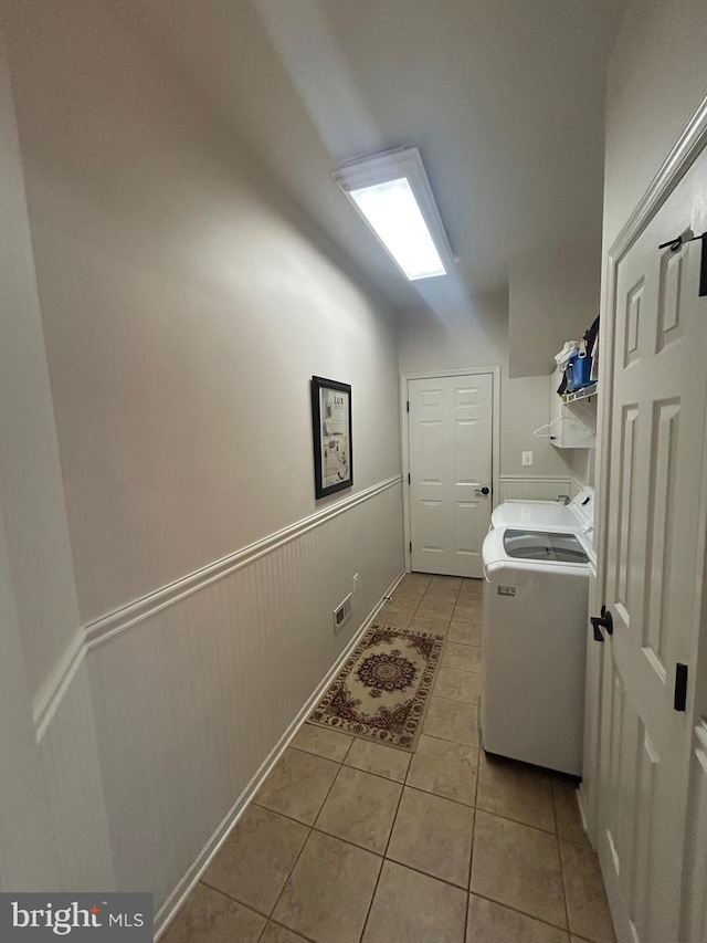 laundry area featuring washing machine and dryer and light tile patterned flooring