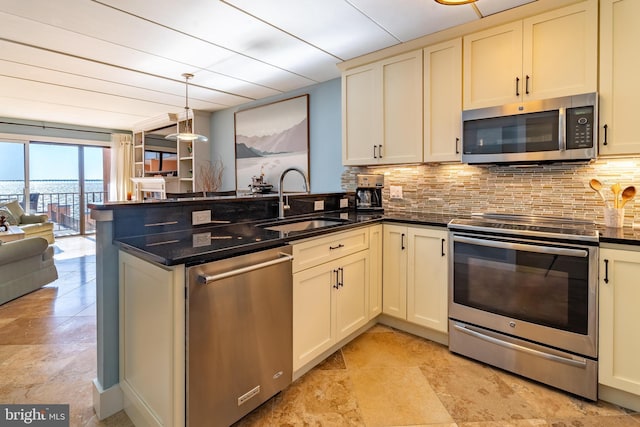 kitchen featuring pendant lighting, stainless steel appliances, sink, and tasteful backsplash