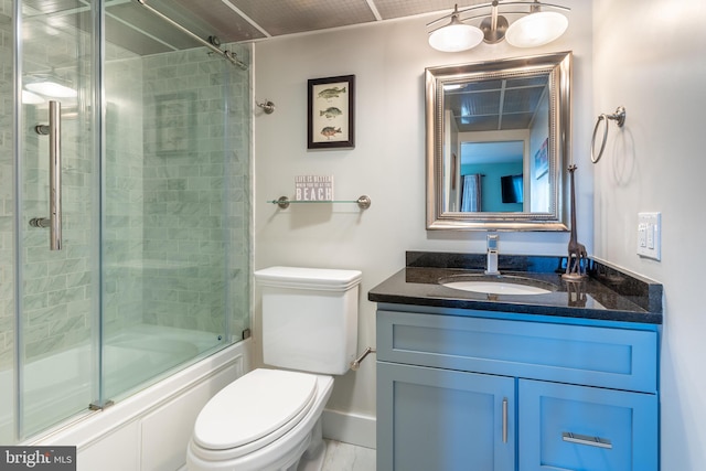 full bathroom featuring vanity, toilet, and combined bath / shower with glass door