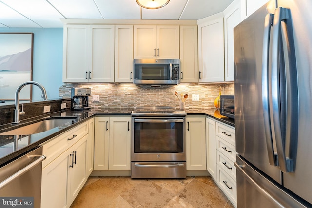 kitchen featuring tasteful backsplash, appliances with stainless steel finishes, sink, and dark stone counters