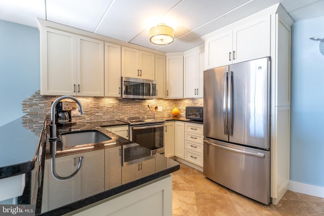 kitchen featuring appliances with stainless steel finishes, sink, white cabinets, backsplash, and kitchen peninsula