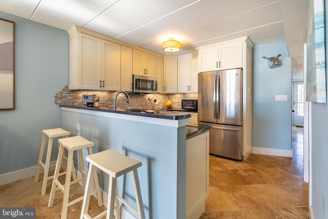 kitchen with stainless steel appliances, kitchen peninsula, and white cabinets