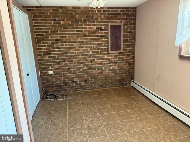 empty room featuring a baseboard radiator and brick wall