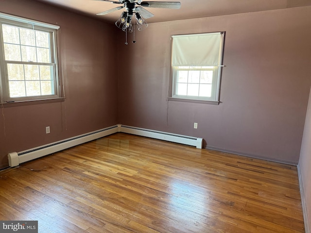 unfurnished room with a baseboard heating unit, ceiling fan, and light hardwood / wood-style flooring