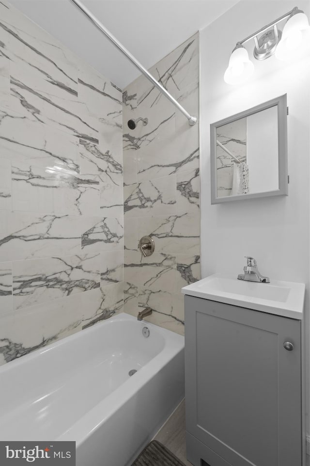 bathroom featuring vanity and tiled shower / bath