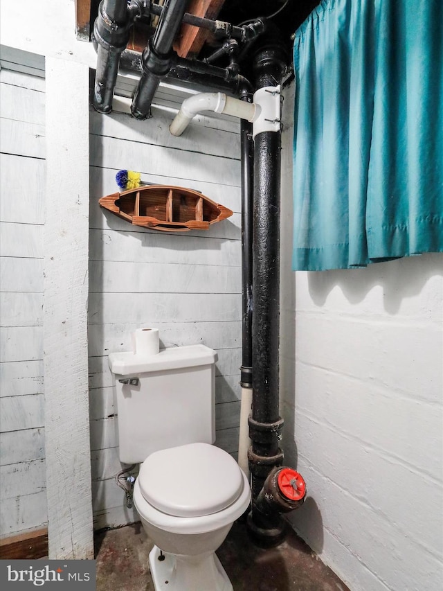 bathroom featuring concrete floors and toilet