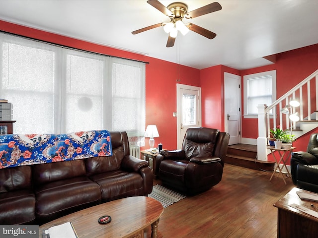 living room with a healthy amount of sunlight, dark wood-type flooring, and ceiling fan