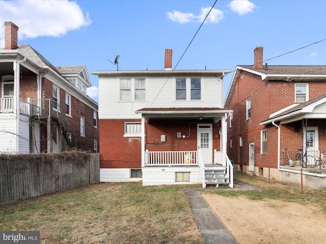 rear view of property with a yard and covered porch