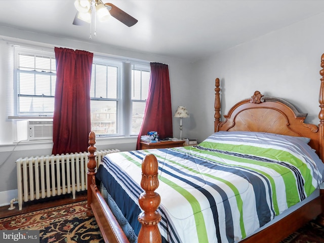 bedroom with hardwood / wood-style flooring, ceiling fan, radiator, and cooling unit