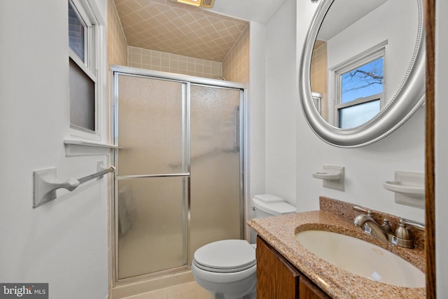 bathroom featuring vanity, toilet, and a shower with shower door