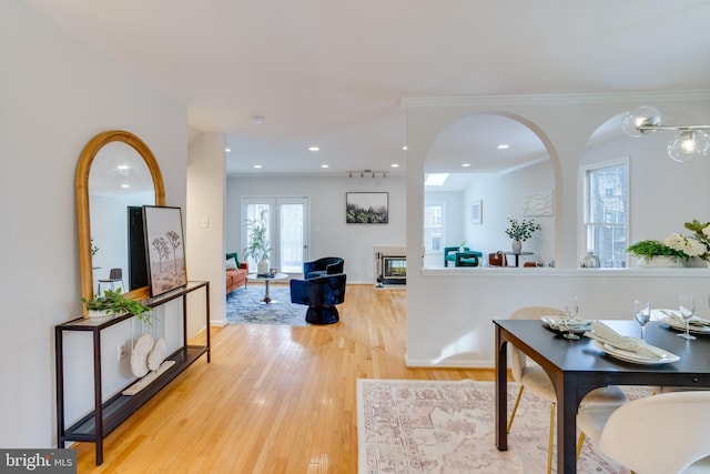 interior space with crown molding, french doors, and light wood-type flooring