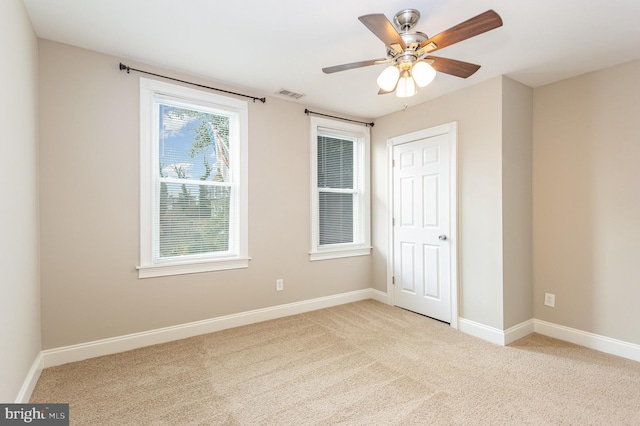 carpeted spare room with ceiling fan