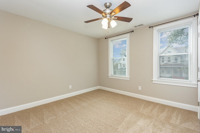 carpeted spare room with ceiling fan