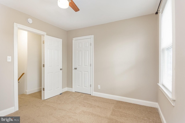 unfurnished bedroom featuring light colored carpet and ceiling fan