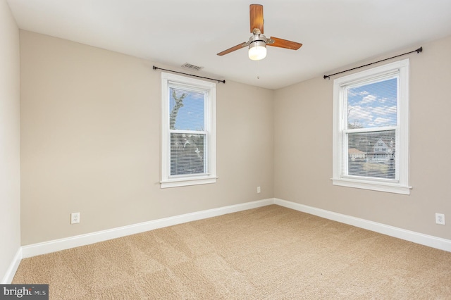 carpeted spare room featuring ceiling fan