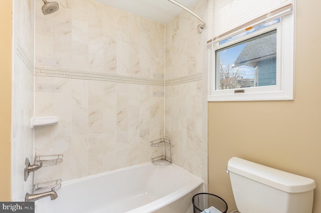 bathroom featuring tiled shower / bath and toilet