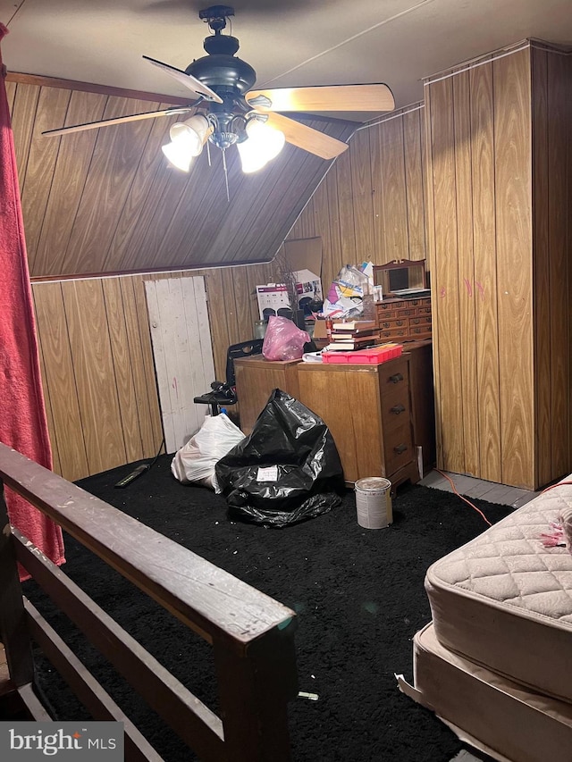 bedroom with wooden walls, ceiling fan, and vaulted ceiling