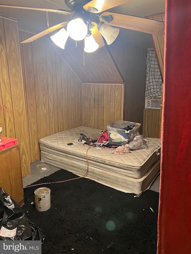 bedroom with ceiling fan and wood walls