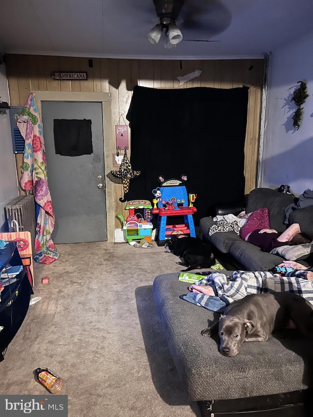 game room featuring carpet, ceiling fan, and wood walls