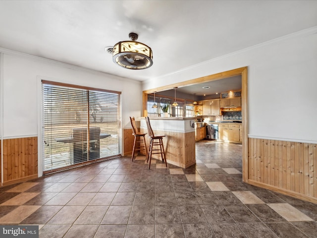 kitchen with decorative light fixtures, wood walls, a kitchen bar, and kitchen peninsula