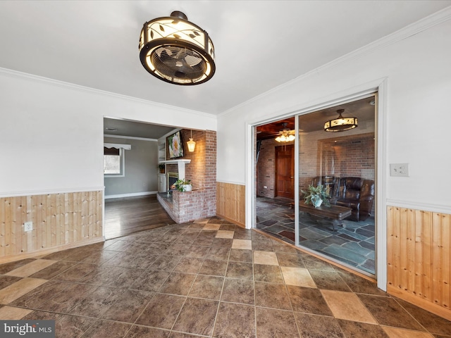 interior space featuring a brick fireplace, crown molding, and wooden walls