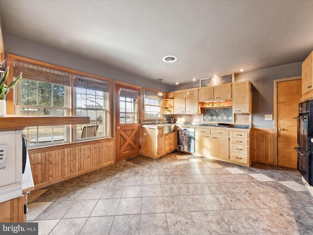 kitchen featuring tasteful backsplash, dishwasher, wood walls, and decorative light fixtures